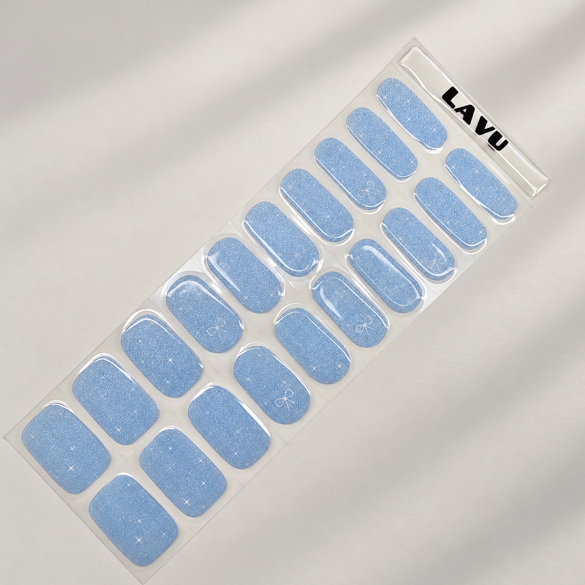 Aqua Twinkle baby blue semi-cured gel nail strips with subtle shimmer, twinkle and ribbon details by LAVU